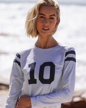 Close up of Perfect 10 UPF50+ relaxed fit rashie on Bondi beach