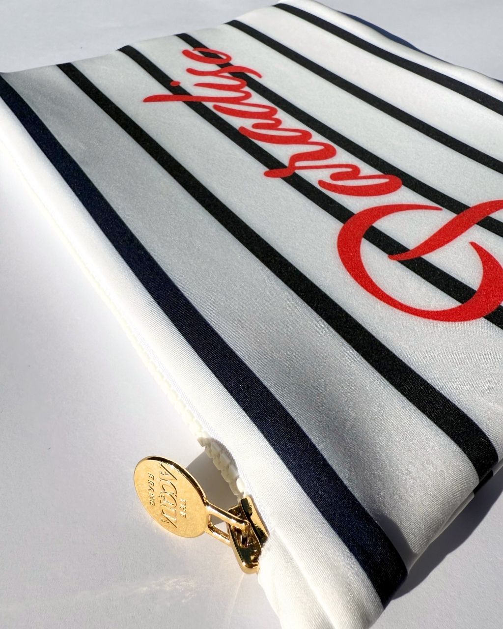 Nautical stripe zip pouch with Paradiso in red written across it