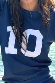 Close-up of the ACQUA Perfect 10 UPF50+ rashguard in navy and white with ‘10’ print.