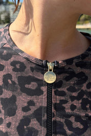 Close-up of the ACQUA leopard print zip long sleeve UPF50+ rash guard with gold zipper.
