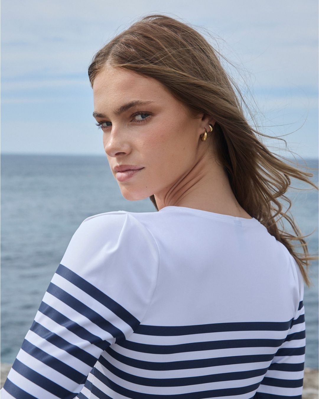 Shoulder and pleat detail of white nautical rashguard