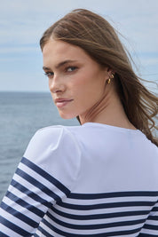 Shoulder and pleat detail of white nautical rashguard